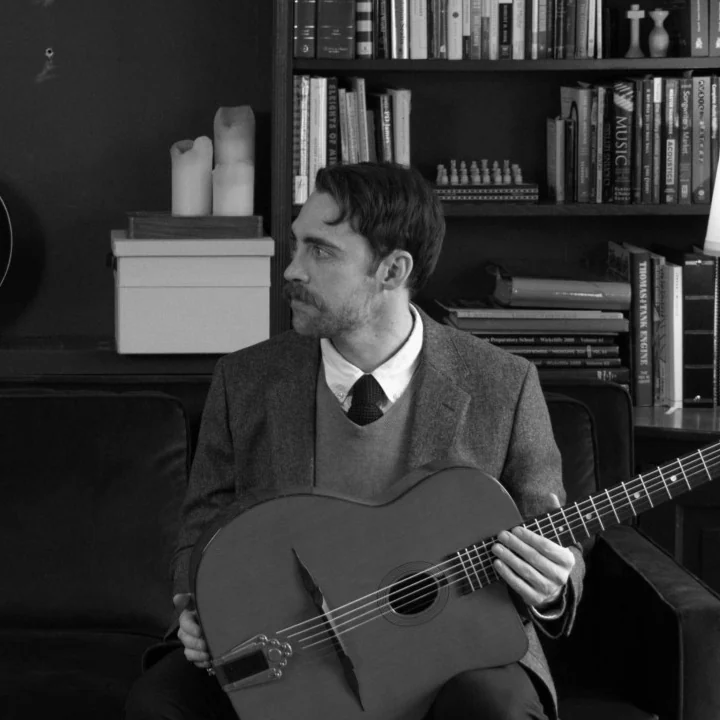 Jordan Call seated with his guitar.